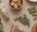 Zelfgemaakt speelgoed: sensorische fles, wasknijpers, houten doppen en een bak met loose parts